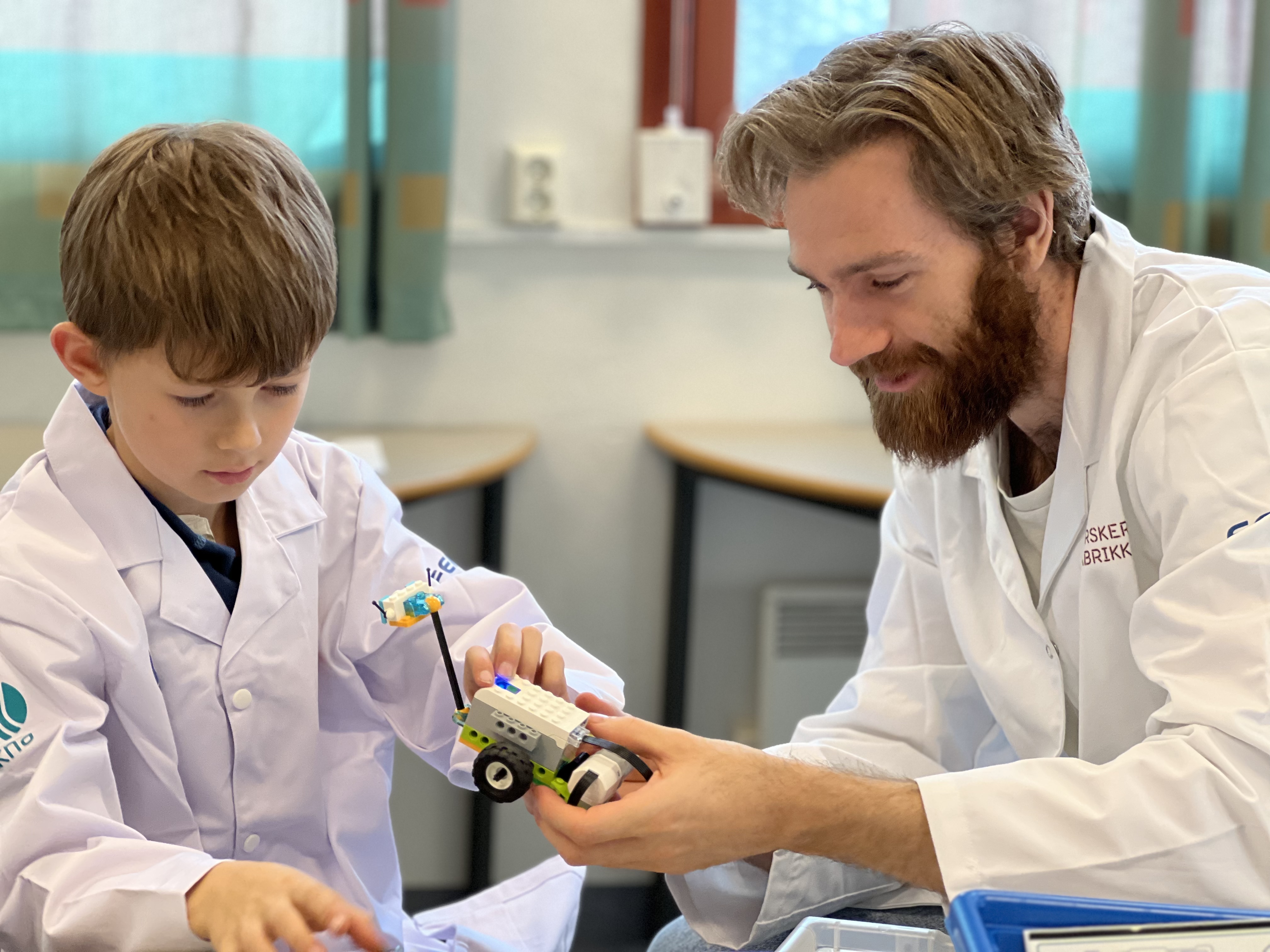 AKS Et barn og en voksen porgrammererer sammen med Lego WeDo.