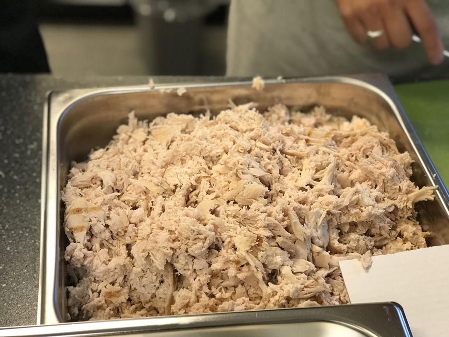 Ferdig revet kylling blir tilsatt kyllingfond for å gjøre den enda mer smakrik og saftig. Nam!